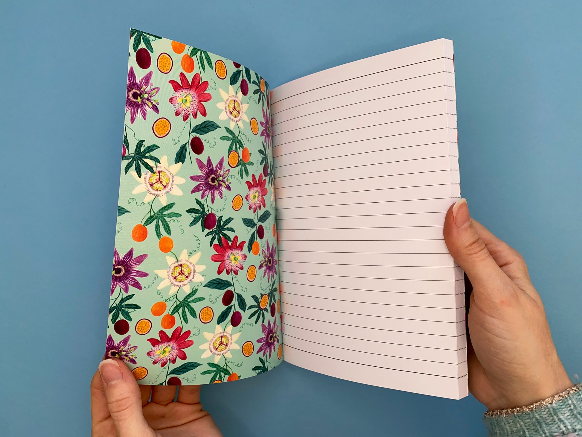 Inside front cover. Same passion fruit and flowers pattern in smaller scale. Pale green background with pale yellow, dark pink, and purple passion flowers. With orange and purple passion fruits and green foliage.