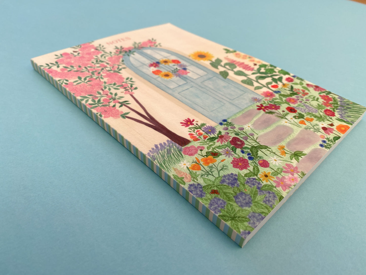 The spine with a stripy pattern of pale yellow, pastel blue and green colours.